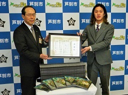 株式会社GYOROGYORO社長から絵本の寄贈を受ける市長